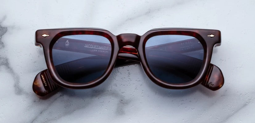 Brown sunglasses with dark lenses on a marble surface
