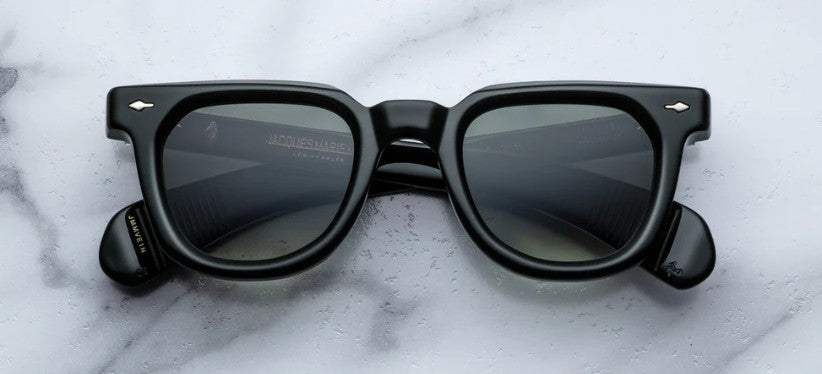 Black sunglasses with reflective lenses on a white marble surface